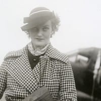 Doris Duke, standing in front of small clipper plane
