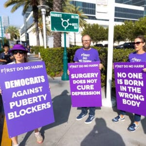 Photo of three protestors holding signs