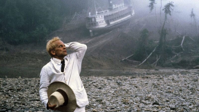 Film still from Fitzcarraldo showing Klaus Kinski with stranded boat
