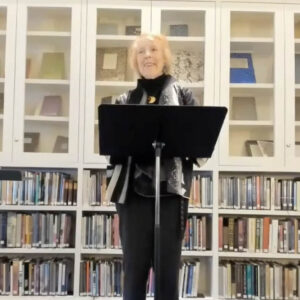 Sallie Bingham reading behind a podium