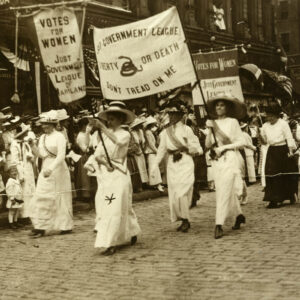 Black and white photo of women marching with large banners