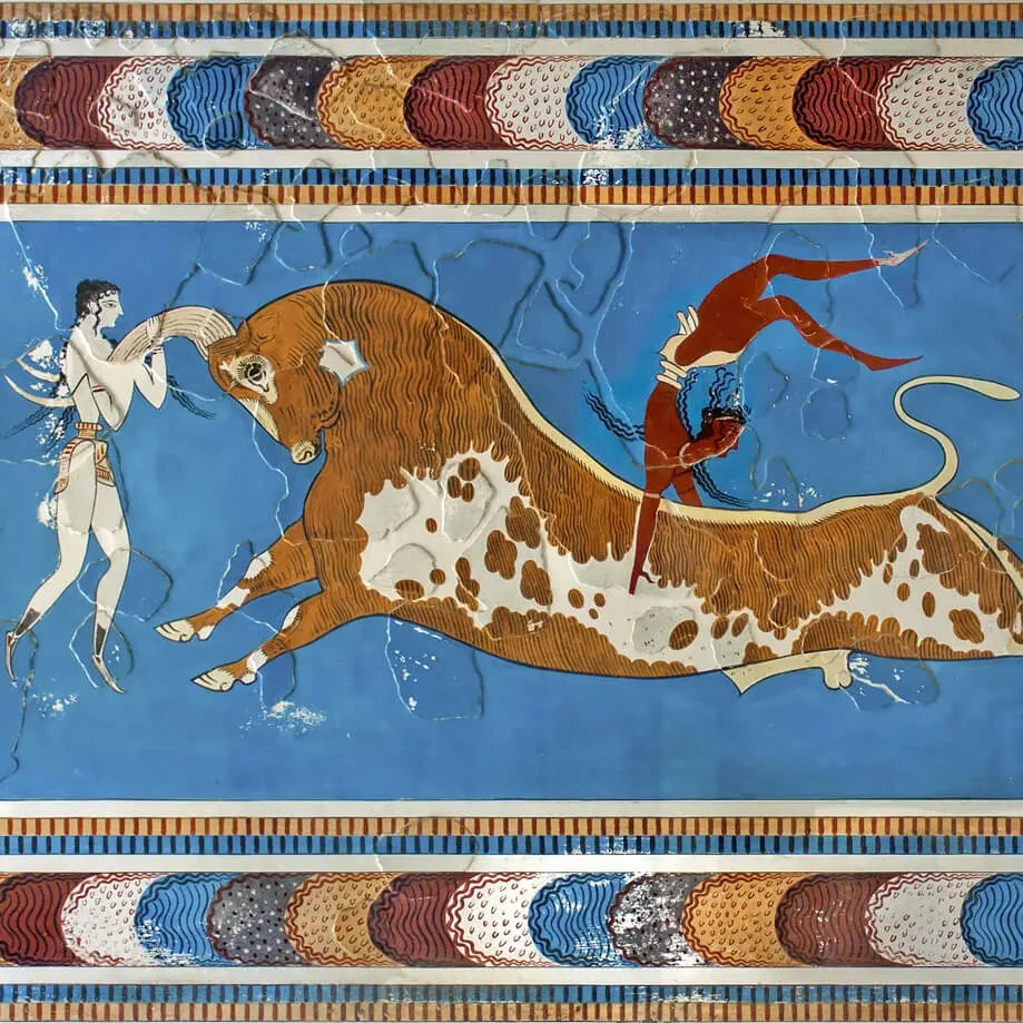 Photo of three figures leaping over a bull