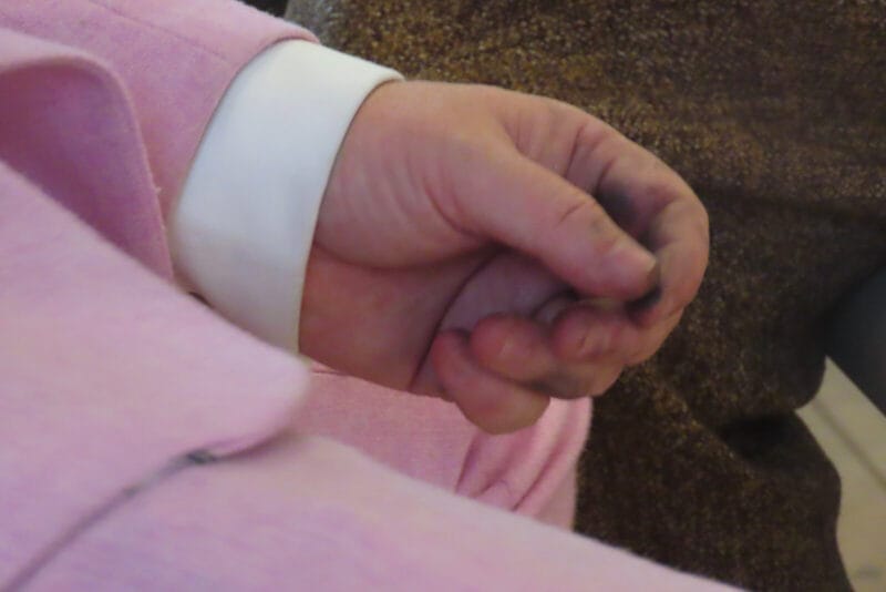 Photo of an elderly woman's hands with charcoal on them
