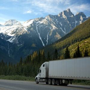 White truck on highway with mountains in the background