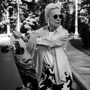 Woman in sunglasses holding a skateboard
