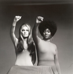 Photo of Gloria Steinem and Dorothy Pitman Hughes, arms raised