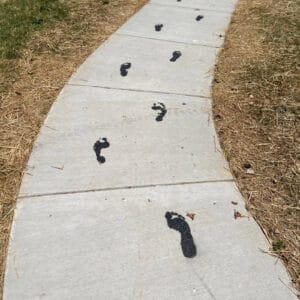 Black footprints on sidewalk